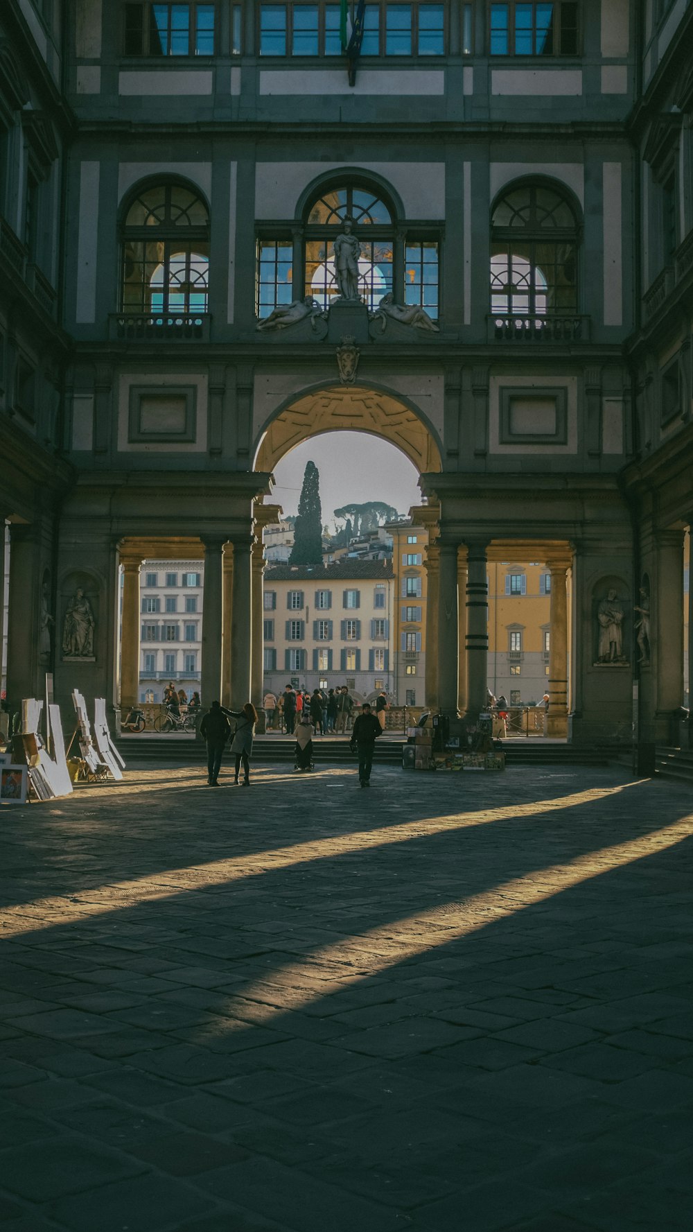 a courtyard with people and a building in the background