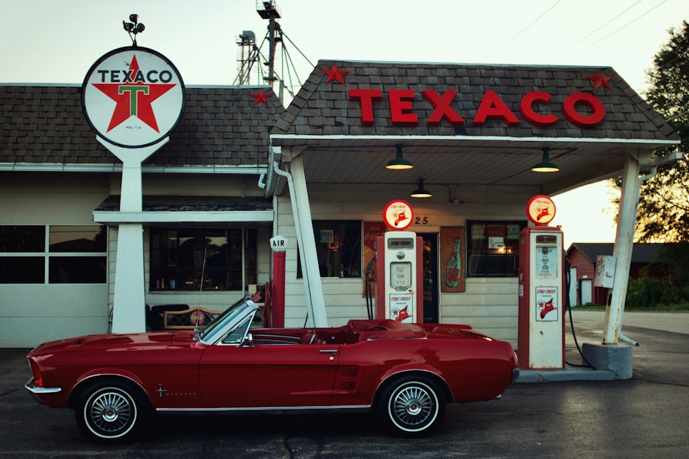 a red car parked in front of a restaurant