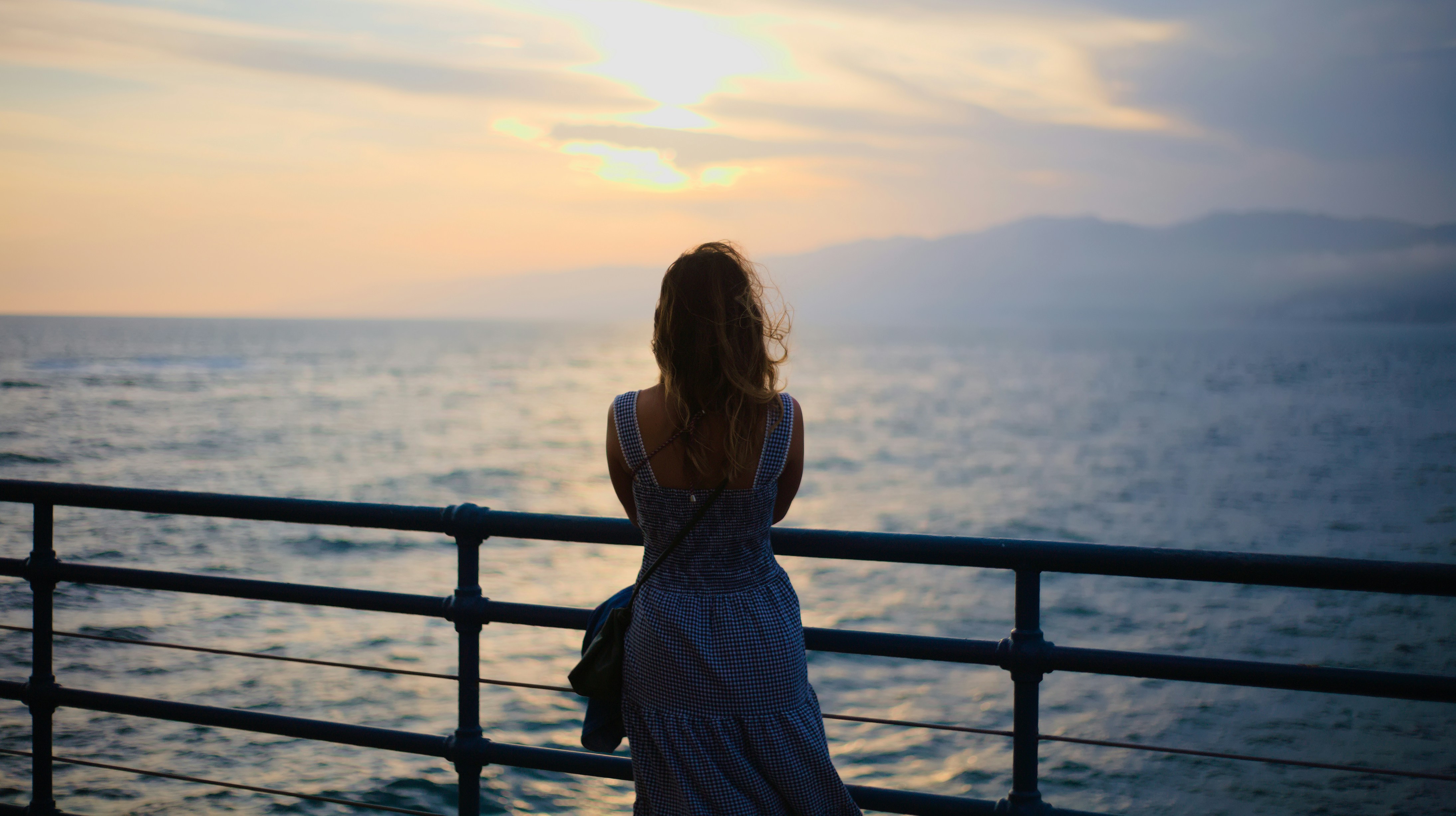 a person standing on a balcony overlooking a body of water