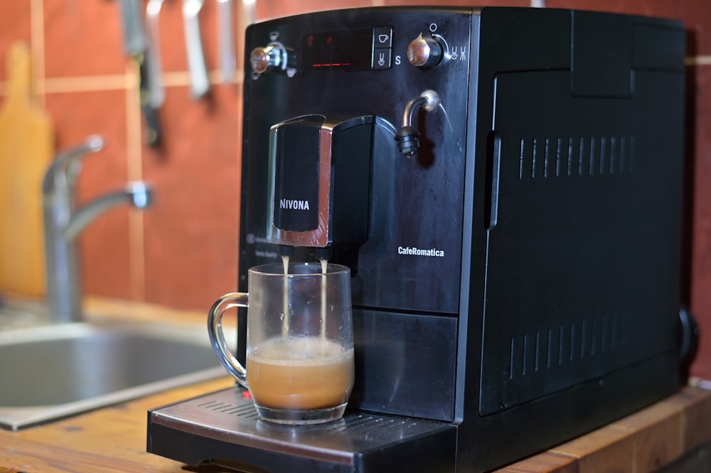 a glass of liquid sits on a coffee maker
