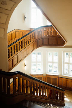 Finished hardwood staircase with detailed railing and warm lighting.
