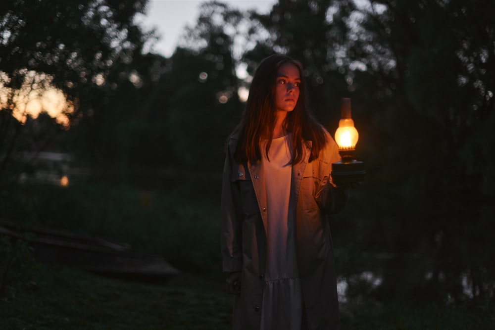 a woman standing outside by a light