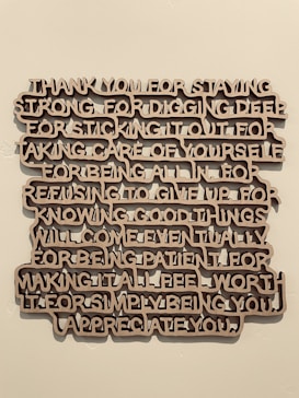 A piece of wall art with text expressing gratitude and appreciation, crafted in a three-dimensional style with brown letters casting shadows against a light wall.