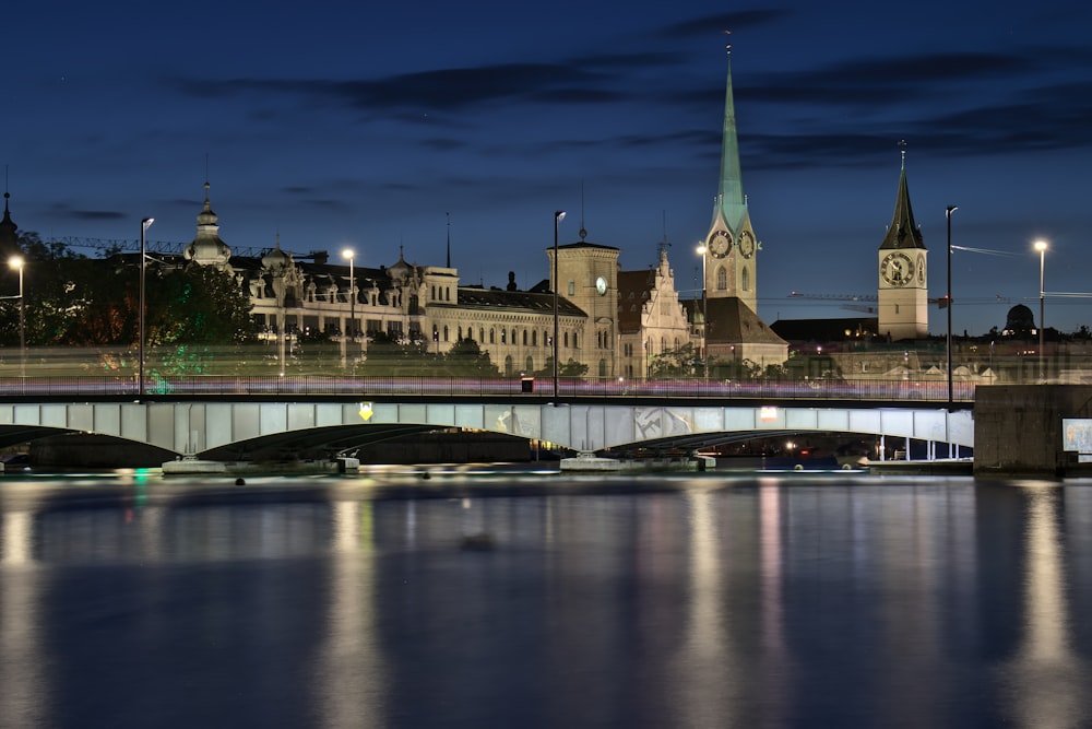 Eine Brücke über einen Fluss mit einem großen Gebäude im Hintergrund