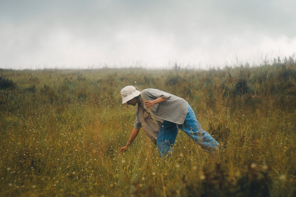 a person bending over in a field