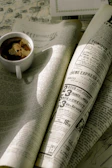 An elegant coffee cup beside an open magazine on a wooden desk.