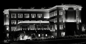 Night view of a well-lit building highlighting architectural details.