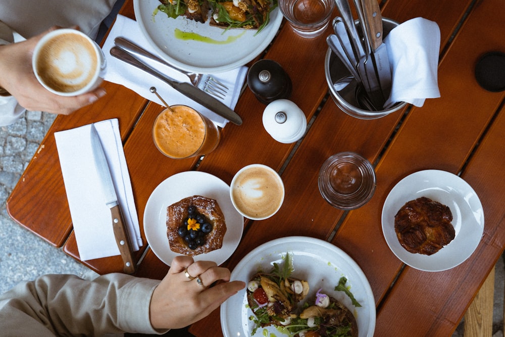 a table with plates of food and cups of liquid