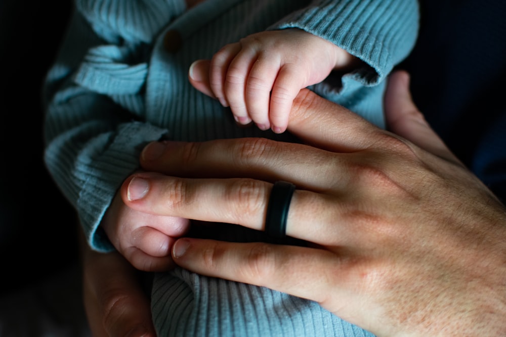 a person holding a baby's hand