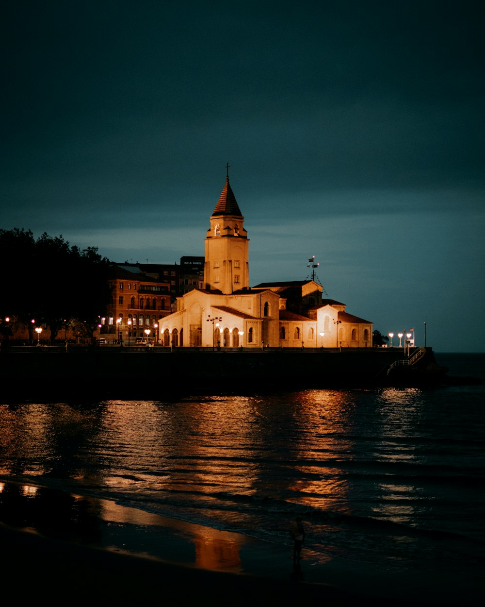 a building with a tower by a body of water