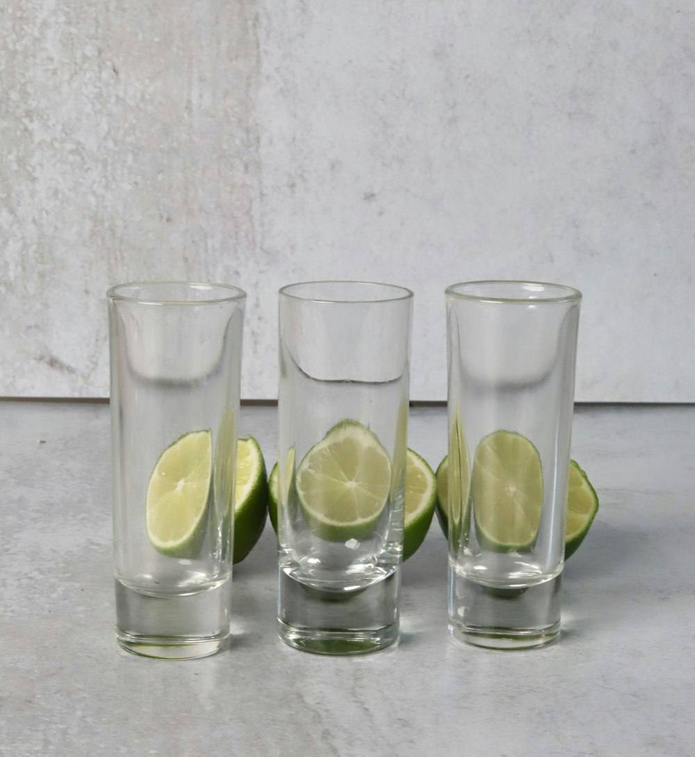 a group of glasses with limes