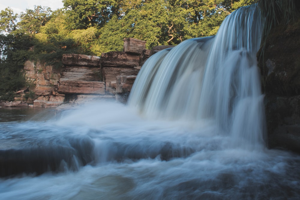 a waterfall with trees in the background