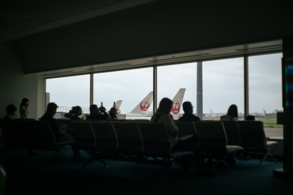 a group of people sitting in a room with large windows