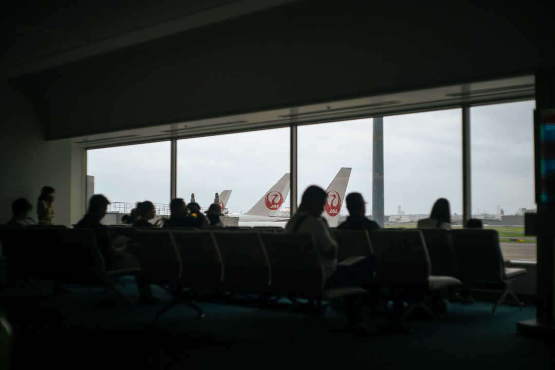 a group of people sitting in a room with large windows,
