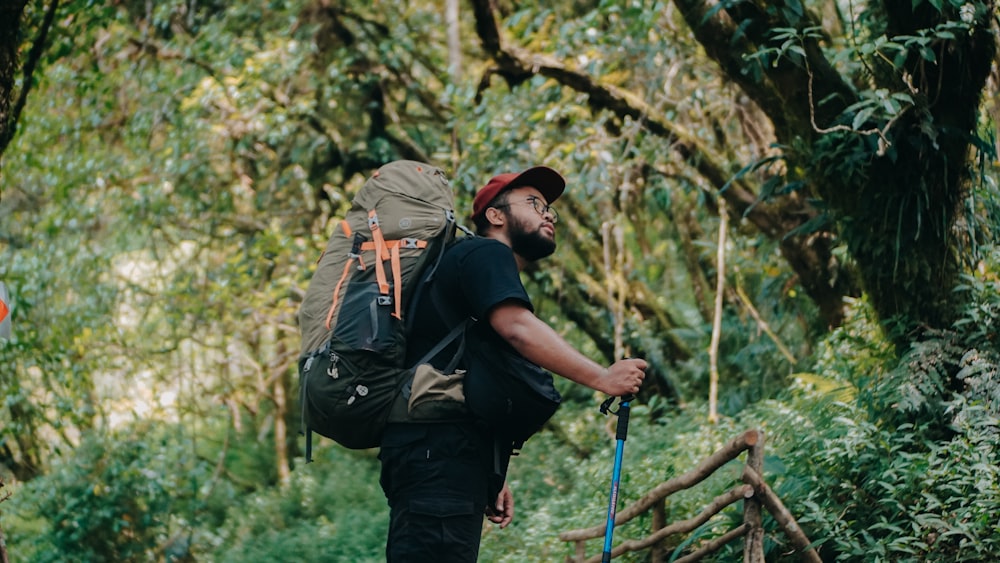 a man with a backpack walking through the woods