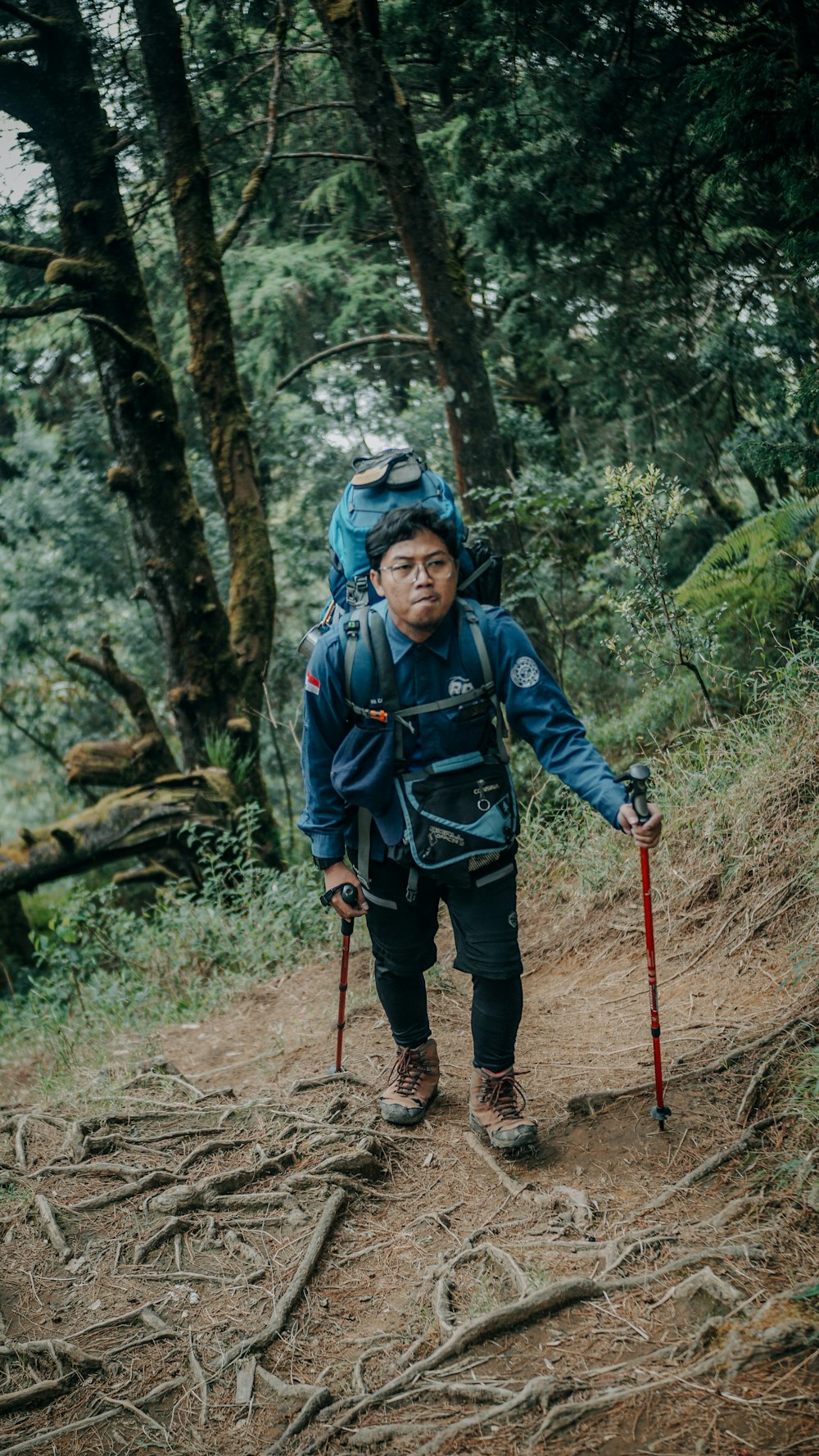 a man wearing a backpack and walking in the woods