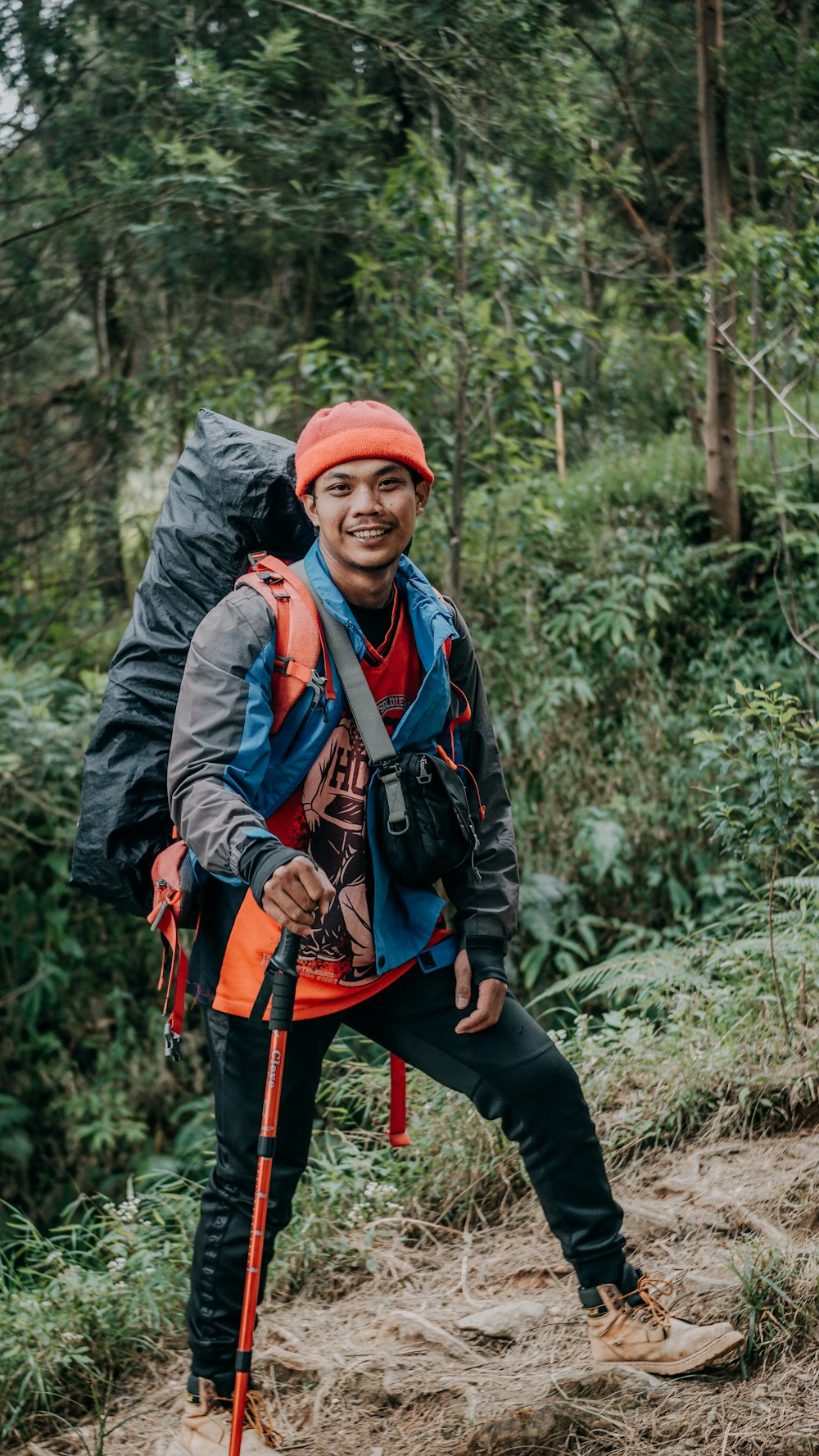 a man wearing a backpack and standing in the woods