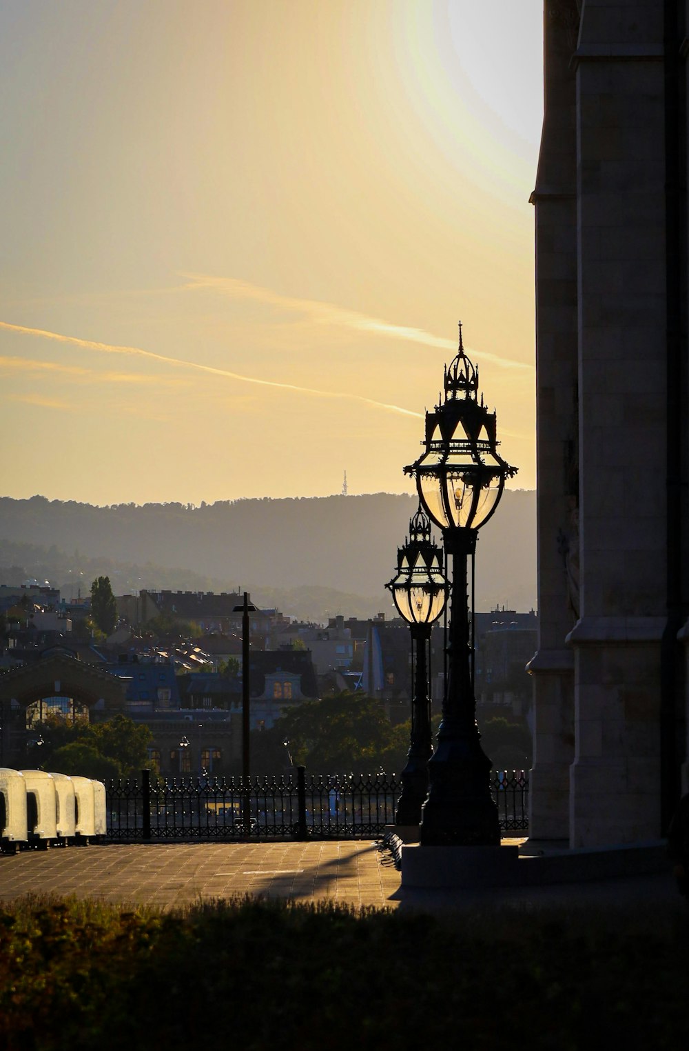 a lamp post with a city in the background