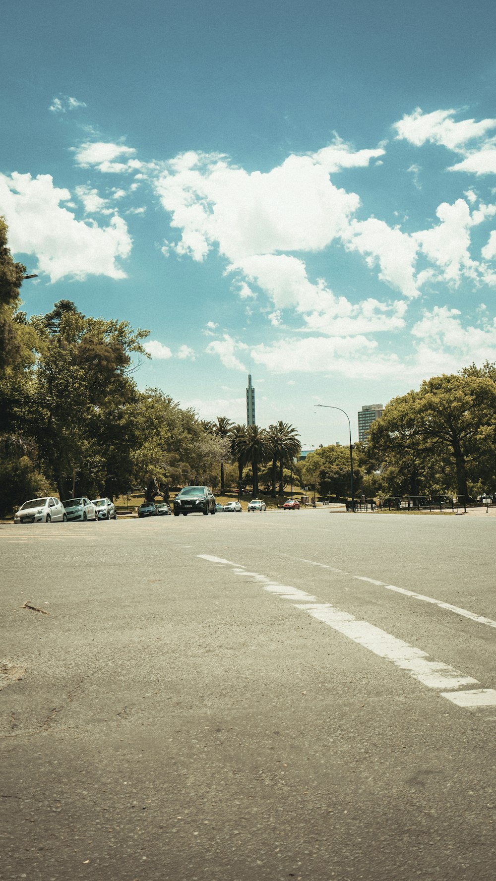 a street with cars on it and trees on the side