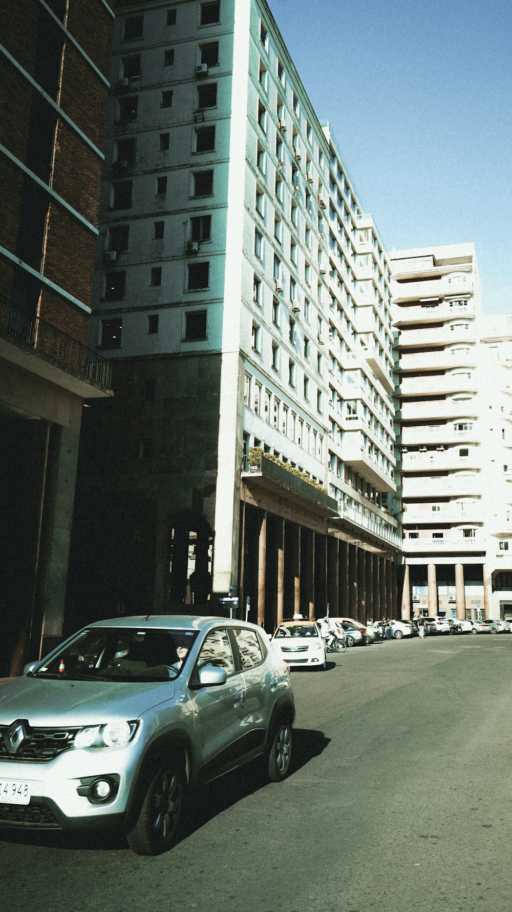 auto parcheggiate sul lato di una strada accanto a un edificio alto