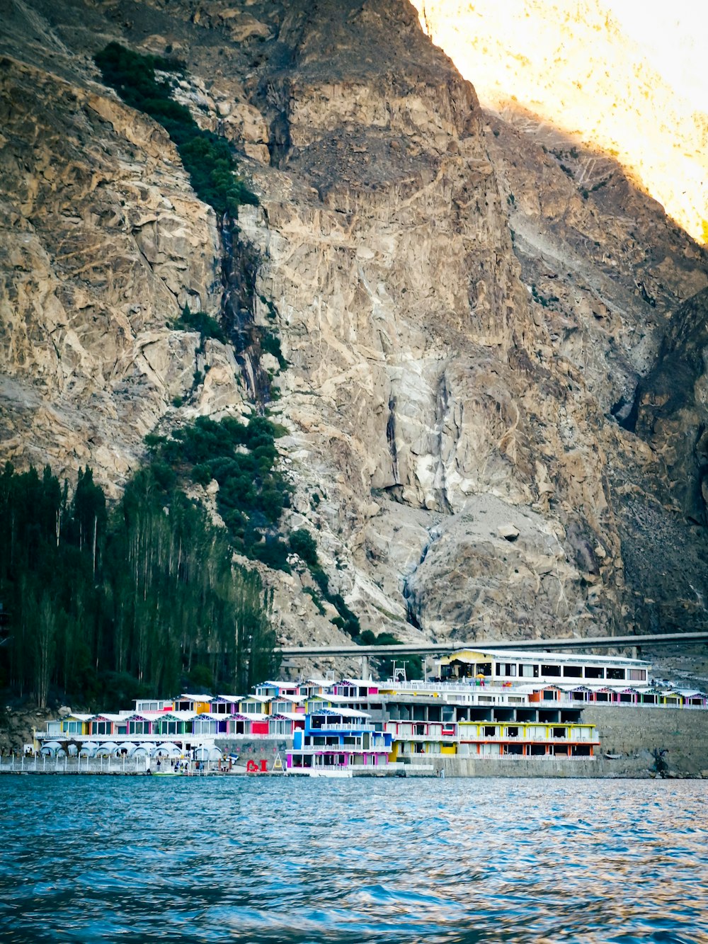 a boat on the water by a cliff