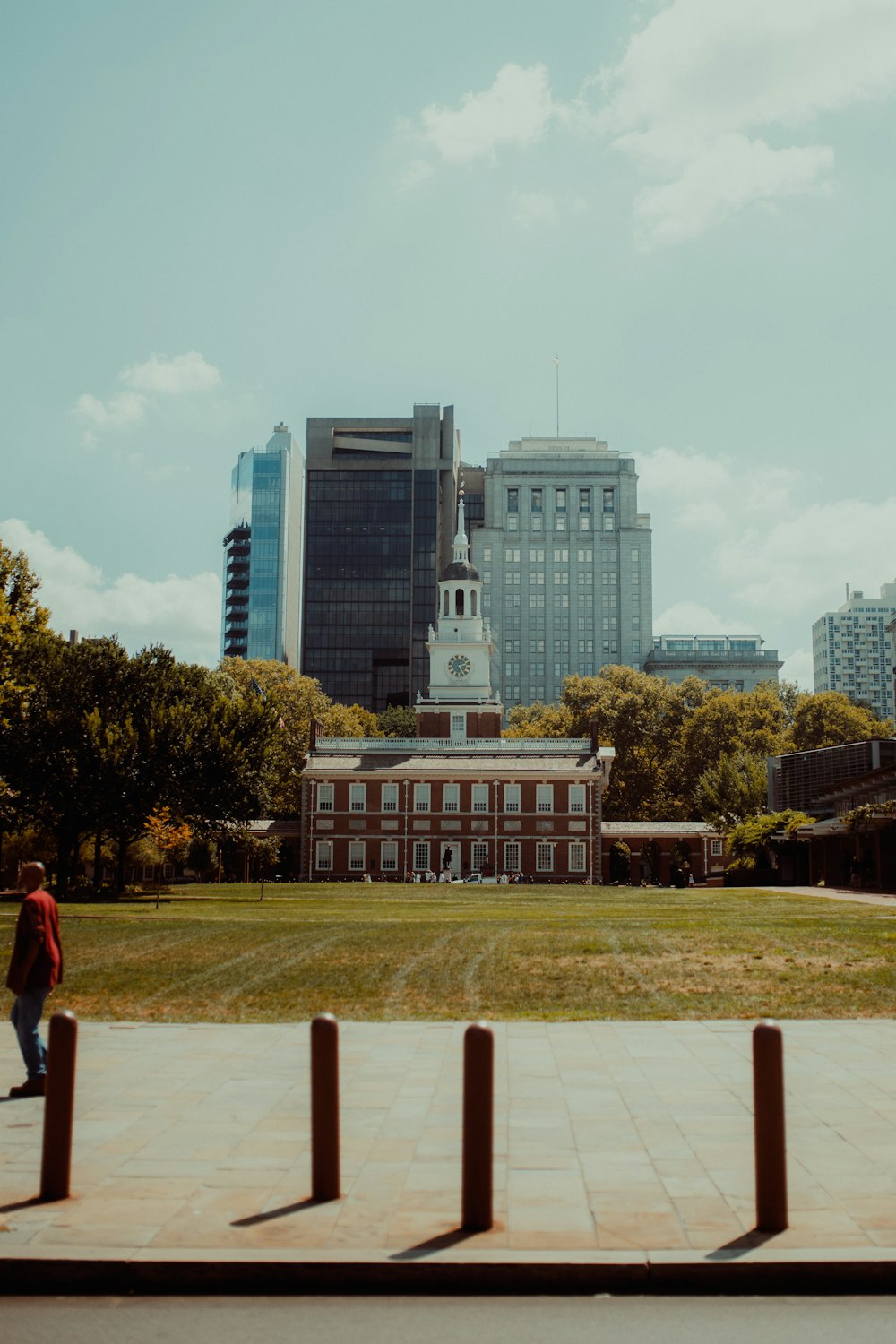 a person walking on a path in front of a building with a tower