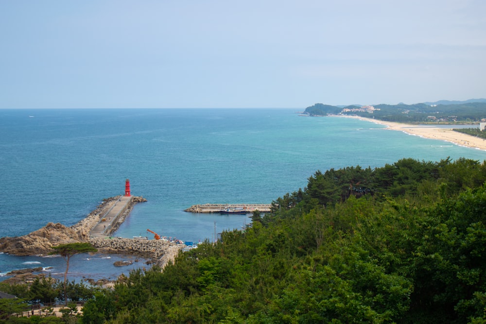 ein Gewässer mit Bäumen und ein Land mit einem Leuchtturm