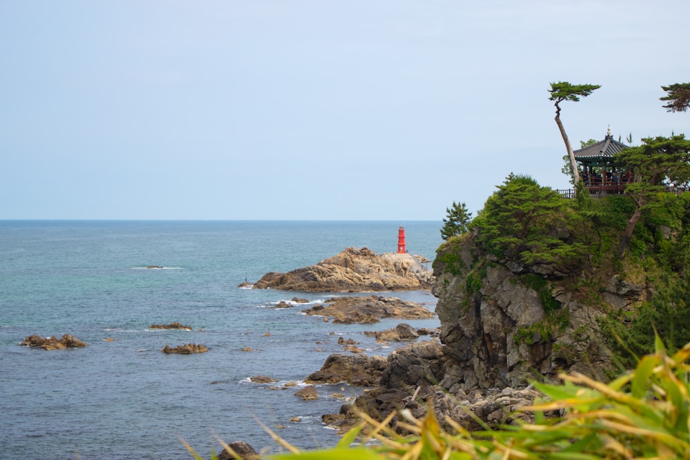 a rocky beach with a red lighthouse