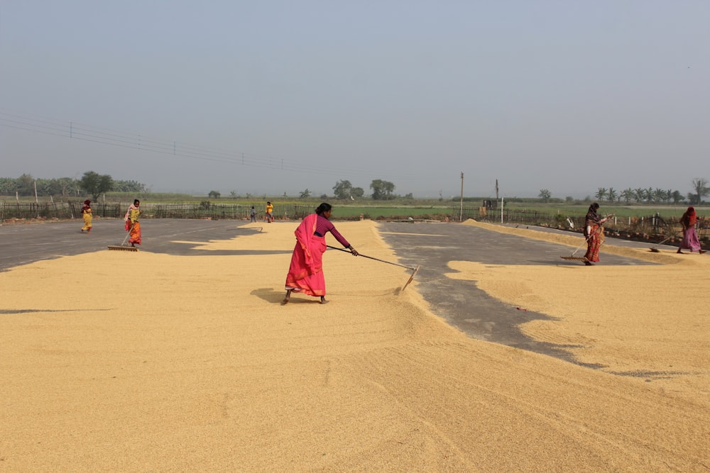 a group of people playing in a sandy area