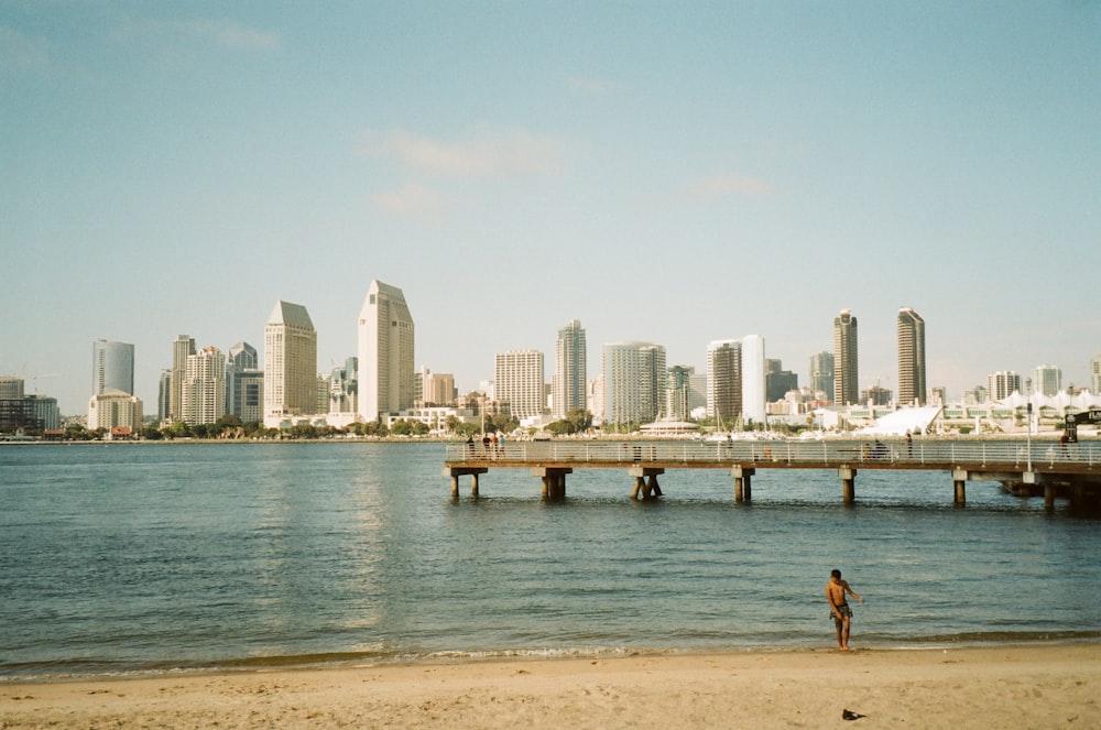 a person standing on a beach with a city in the background