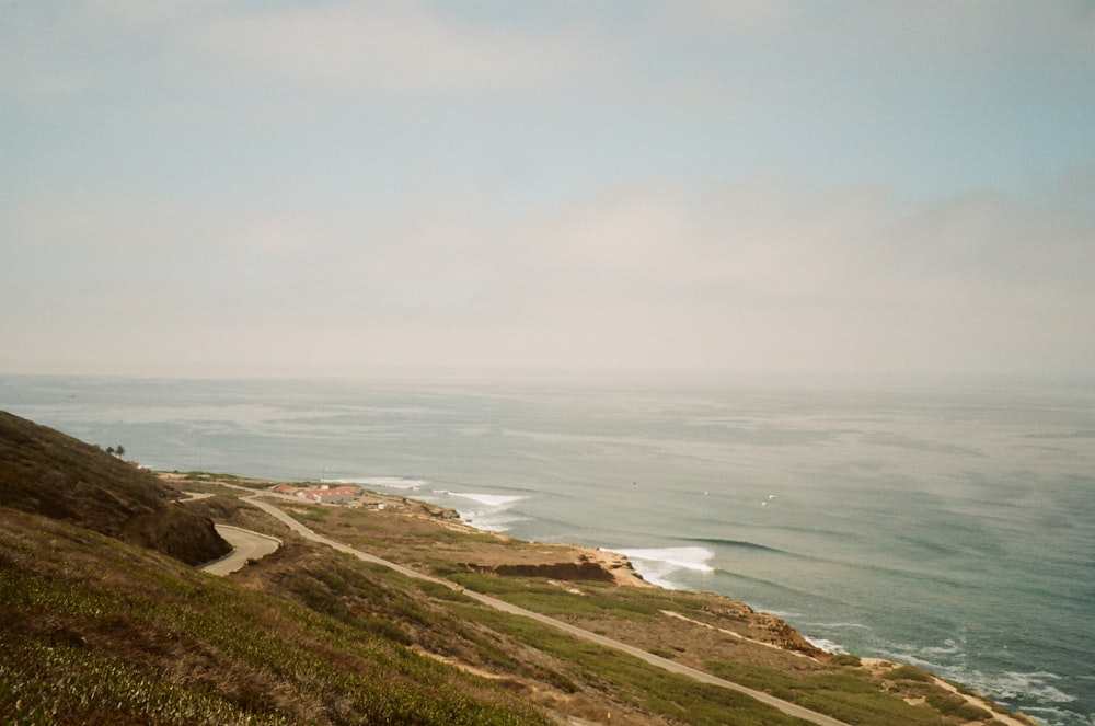 a grassy hill overlooking a body of water