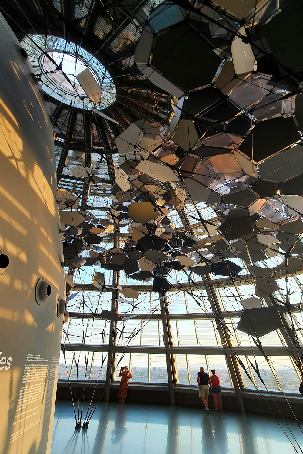 a large clock hangs from a ceiling