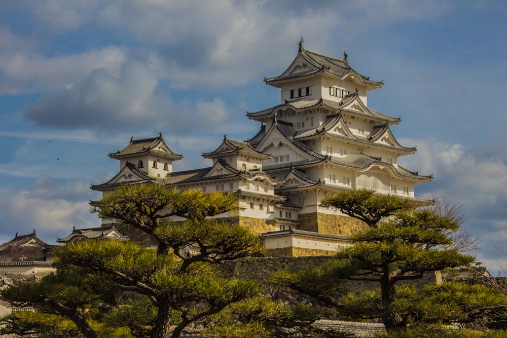 a large building with trees in front of it with Himeji Castle in the background