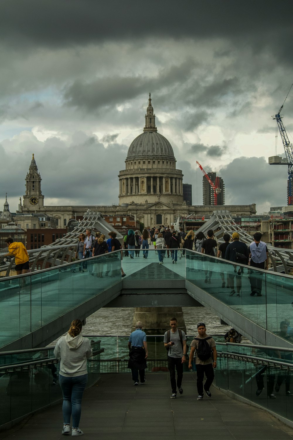 a group of people standing on a bridge over a body of water