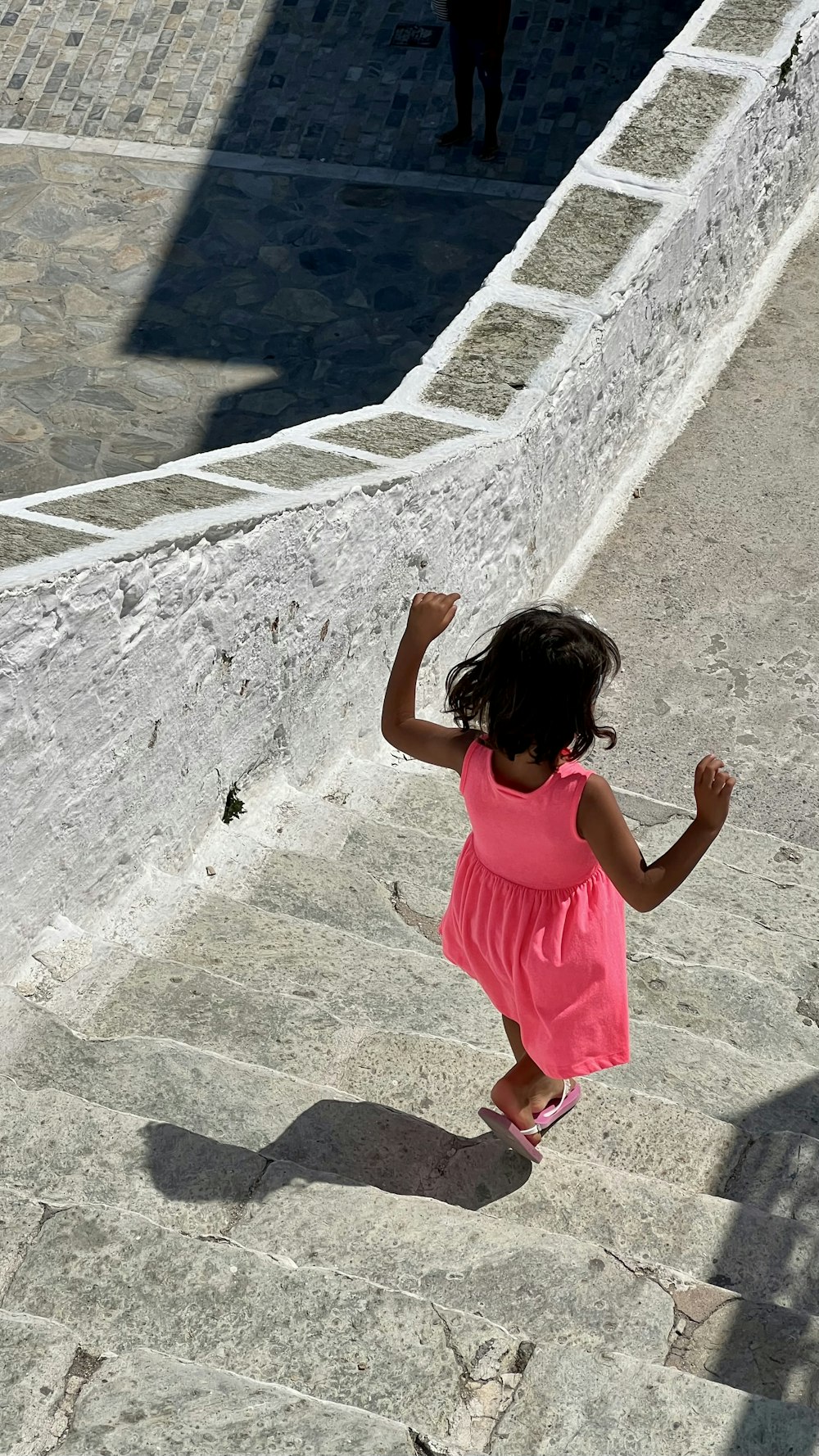 uma menina em pé em uma passarela de pedra