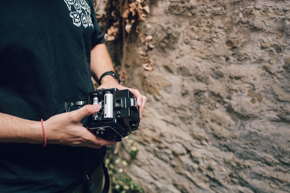 una persona che tiene in mano una macchina fotografica