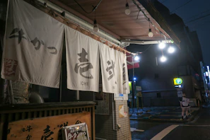 The komemori storefront sign glowing softly in the evening light in Des Moines