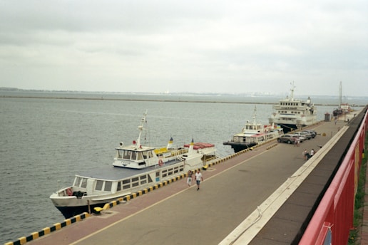 a group of boats are parked on the side of a river