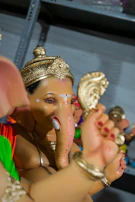 A detailed shot of a Ganesh idol's face, highlighting the eco-friendly paint and natural textures.
