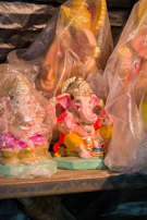A set of small Ganesh idols made from recycled paper pulp, arranged on a bamboo mat.