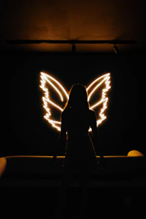 Minimalist angel wings illustration with delicate lines and a warm, neutral color palette.