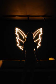 Elegant minimalistic angel wings silhouette with gentle glow on neutral background
