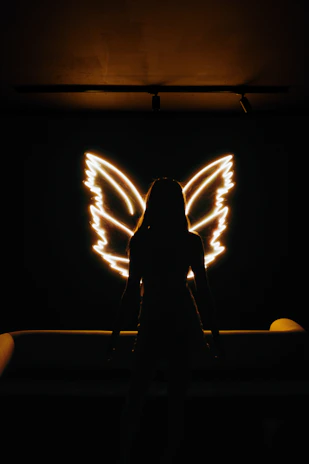Minimalist angel wings illustration with delicate lines and a warm, neutral color palette.