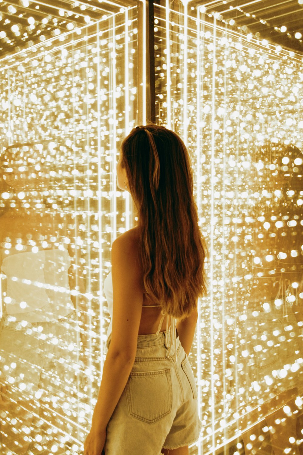 a woman standing in front of a wall of lights