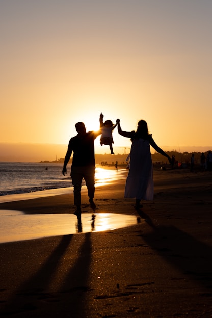 a man and woman holding hands on a beach
