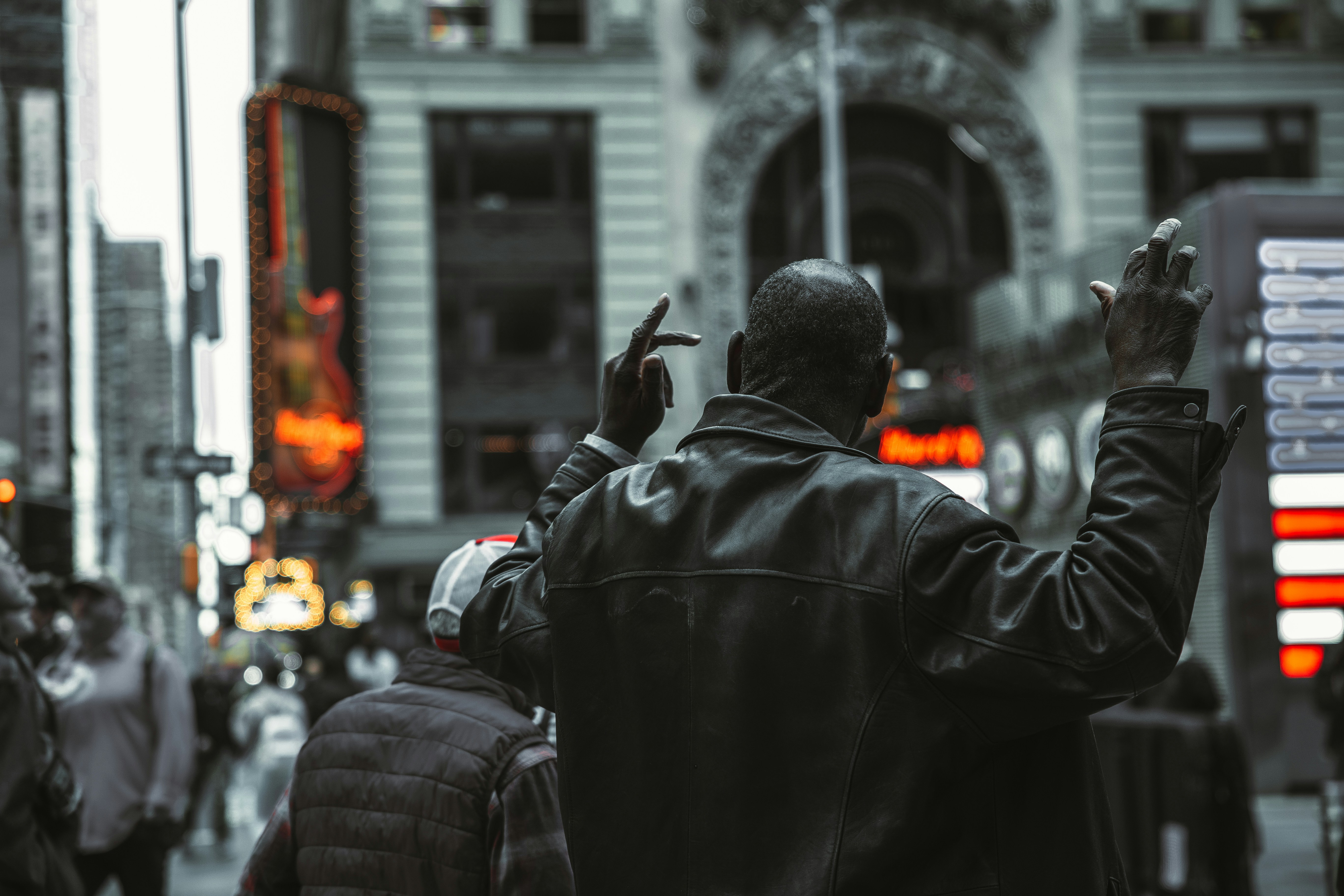 a person in a black coat holding the hands up