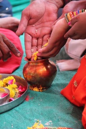 Close-up of traditional Telugu wedding rituals being performed with flower petals falling.