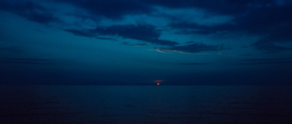 a body of water with a red light in the distance