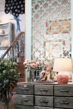 A friendly mover carefully carrying a vintage dresser down a narrow staircase.