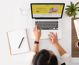 a person sitting at a desk with a laptop and a coffee cup